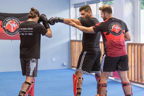 Ο προπονητής διορθώνει την κατάλληλη θέση του αθλητή για την επίθεση.