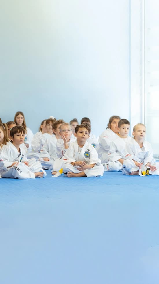 Μια σειρά από παιδιά που κάθονται οκλαδόν στο χώρο του αθλητικού συλλόγου